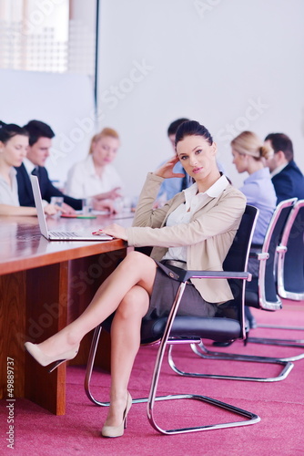 Photo: business woman with her staff in background at office business woman with her staff in background at office