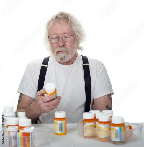 Photo: Senior looking at a bottle of pills Senior looking at a bottle of pills