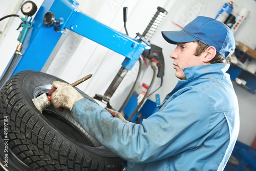 Photo: repairman mechanic lubricating car tyre repairman mechanic lubricating car tyre