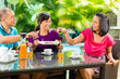 Foto: Asian friends having coffee on home porch Asian friends having coffee on home porch