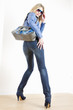 standing woman wearing blue clothes with handbag