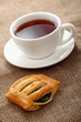 Cup of tea with buns on a tablecloth