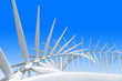 Modern windmills with the blades turning together at slightly