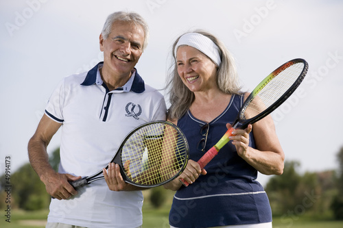 Photo: Mature couple holding tennis racquets Mature couple holding tennis racquets