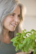 Mature woman holding basel plant
