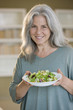 Mature woman holding bowl of salad