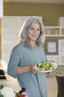 Mature woman holding bowl of salad