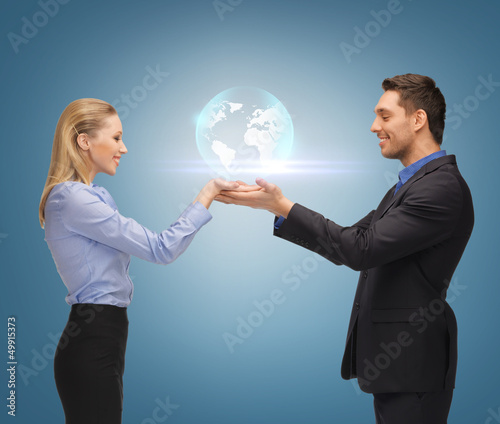 Photo: man and woman showing earth globe on the palms man and woman showing earth globe on the palms
