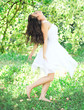 Photo: Beautiful young woman dancing in the morning bright summer orcha Beautiful young woman dancing in the morning bright summer orcha