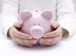 Photo: Piggy bank protected by hands Piggy bank protected by hands