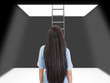 woman standing in a pit looking up to the ladder that leads out