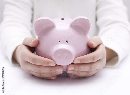Photo: Piggy bank protected by hands Piggy bank protected by hands