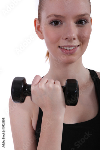 Photo: Young woman with a dumbbell Young woman with a dumbbell