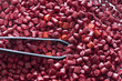 Red plastic masterbatch granules with a tweezers