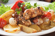 Rolled chicken skewer roasted with potatoes and vegetables