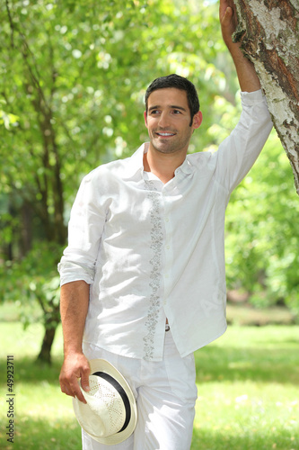 Photo: Man leaning against tree Man leaning against tree
