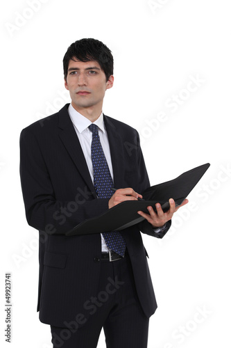 Photo: Man writing in business document folder Man writing in business document folder