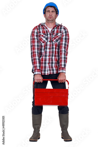 Photo: Worker trying to carry heavy toolbox Worker trying to carry heavy toolbox