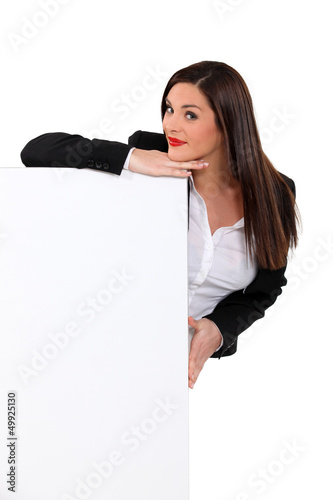 Photo: Brunette woman behind white panel Brunette woman behind white panel