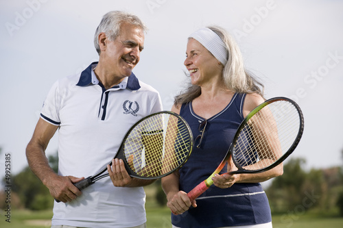 Photo: Mature couple holding tennis racquets Mature couple holding tennis racquets