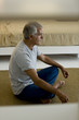 Mature man doing yoga in bedroom