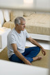 Mature man doing yoga in bedroom