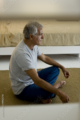 Photo: Mature man doing yoga in bedroom Mature man doing yoga in bedroom