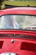 Mature man enjoying a road trip in a small red car