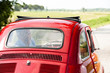 Mature man enjoying a road trip in a small red car
