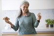 Mature woman deciding between croissant and rice cake