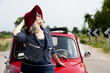 Mature woman enjoying a road trip in a small red car