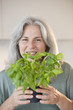 Mature woman holding basel plant