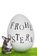 Frohe Ostern Ei auf grüner Wiese mit Osterhasen