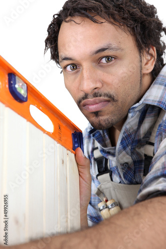 Photo: Man using spirit-level to check cabinet door Man using spirit-level to check cabinet door