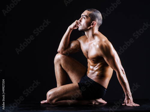 Photo: Muscular man in dark studio Muscular man in dark studio