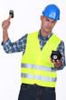 Construction worker breaking open a piggy bank