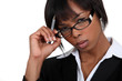 Stern businesswoman touching her glasses