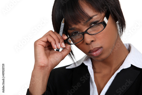 Photo: Stern businesswoman touching her glasses Stern businesswoman touching her glasses