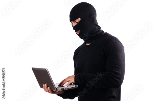 Photo: Hacker with computer wearing balaclava Hacker with computer wearing balaclava