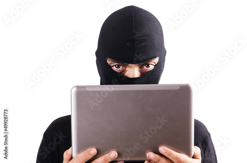 Photo: Hacker with computer wearing balaclava Hacker with computer wearing balaclava
