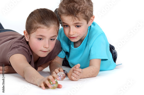 Photo: Brother and sister playing with marbles Brother and sister playing with marbles