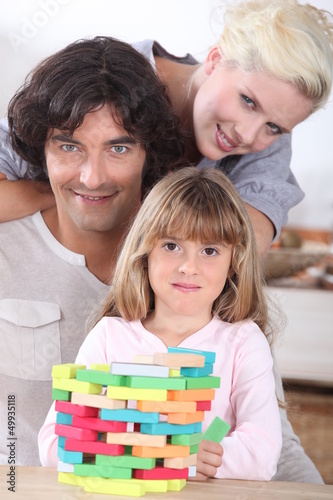 Photo: Couple playing a stacking game with their daughter Couple playing a stacking game with their daughter
