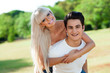 Cute couple piggybacking outdoors.
