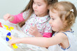 Two little girls sculpting using clay