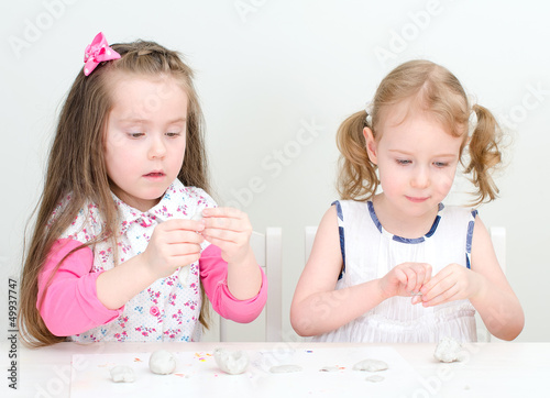 Photo: Two little girls sculpting using clay Two little girls sculpting using clay