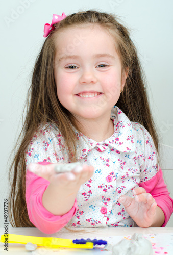 Photo: Cute smiling girl sculpting using clay Cute smiling girl sculpting using clay