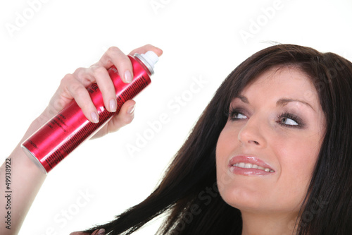 Photo: Woman with bottle of hairspray Woman with bottle of hairspray