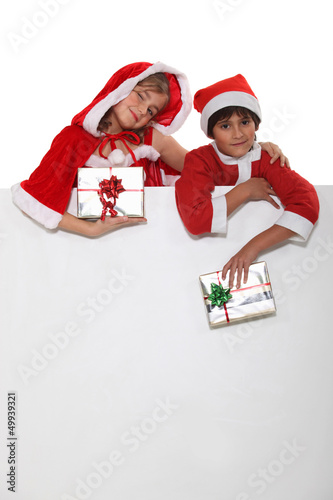 Photo: Brother and sister dressed in Santa Claus outfits Brother and sister dressed in Santa Claus outfits