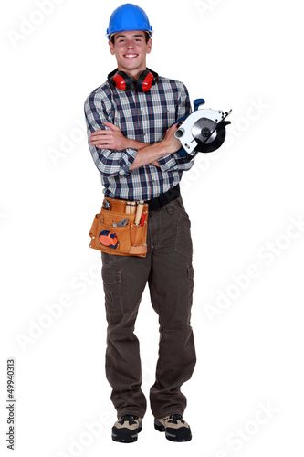 Photo: Portrait of a young tradesman holding a circular saw Portrait of a young tradesman holding a circular saw