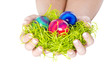 Frau im Osterhasenkostüm mit Ostereiern und Gras in der Hand